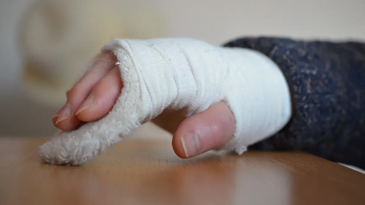 Złamany nadgarstek w bandażu. Czas rehabilitacji po złamaniu nadgarstka jest kluczowy dla powrotu do sprawności.