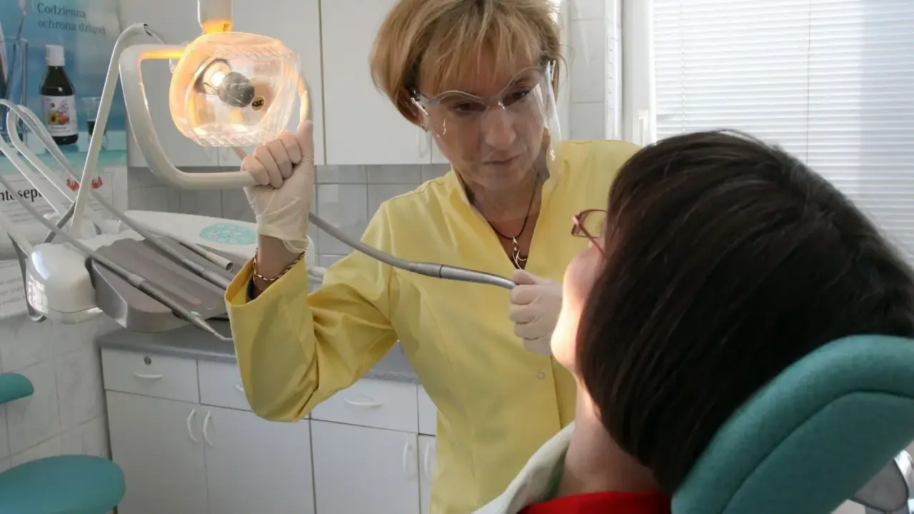 Dentystka w Koninie pomaga pacjentowi, który cierpi gdzie z bólem zęba.