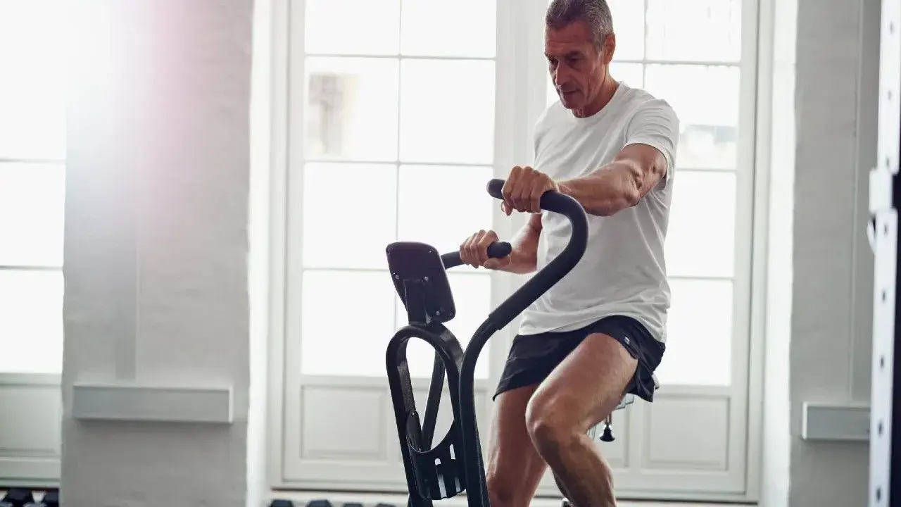 Mężczyzna ćwiczy na rowerze stacjonarnym, który może być dobrym wyborem, jeśli zastanawiasz się, jaki rower stacjonarny do rehabilitacji wybrać.