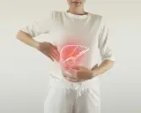 Kobieta trzyma się za brzuch, gdzie widoczny jest zarys wątroby z czerwonym podświetleniem. Może to symbolizować ból wątroby i jego objawy.