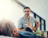 Fizjoterapeuta pomaga pacjentowi w ćwiczeniach rehabilitacyjnych, by odzyskać sprawność.