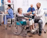 Rehabilitacja po udarze w szpitalu: starsza pani ćwiczy z fizjoterapeutą, by odzyskać sprawność.