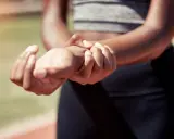 Sportowiec masuje bolący nadgarstek po skręceniu. Czy potrzebne będzie L4?