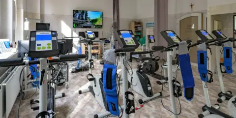 Sala rehabilitacji kardiologicznej z bieżniami i rowerami stacjonarnymi. Tu znajdziesz najlepszą rehabilitację kardiologiczną.