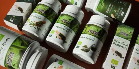 Słoiki i pudełka z produktami **spirulina i chlorella** od Bio Organic Foods. Zielone suplementy diety w proszku i tabletkach.