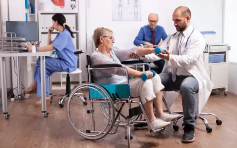 Rehabilitacja po udarze w szpitalu: starsza pani ćwiczy z fizjoterapeutą, by odzyskać sprawność.