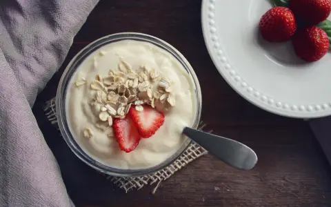 Jogurt z płatkami owsianymi i truskawkami. Idealne jedzenie po wyrwaniu zęba, łagodne i pożywne.