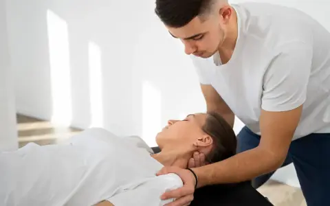 Fizjoterapeuta wykonuje terapię manualną szyi pacjentki. Czy fizjoterapeuta może wystawić receptę? To pytanie nurtuje wielu pacjentów.