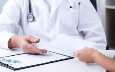 Lekarz przekazuje pacjentowi skierowanie. Szukasz, gdzie najszybciej rehabilitacja NFZ CzęSTOCHOWA?