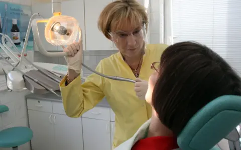 Dentystka w Koninie pomaga pacjentowi, który cierpi gdzie z bólem zęba.