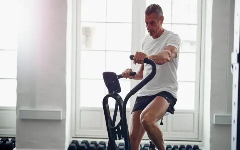 Mężczyzna ćwiczy na rowerze stacjonarnym, który może być dobrym wyborem, jeśli zastanawiasz się, jaki rower stacjonarny do rehabilitacji wybrać.