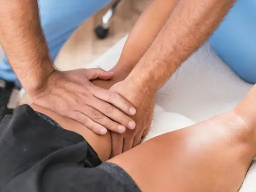 Fizjoterapeuta masuje udo pacjenta. Zastanawiasz się, ile godzin trwa etat fizjoterapeuty?