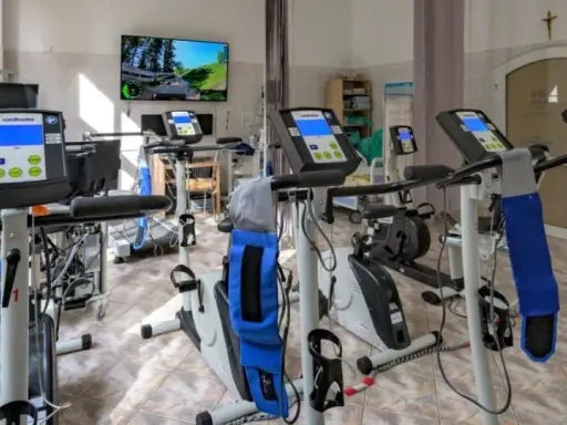 Sala rehabilitacji kardiologicznej z bieżniami i rowerami stacjonarnymi. Tu znajdziesz najlepszą rehabilitację kardiologiczną.