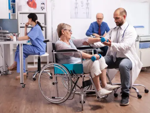 Rehabilitacja po udarze w szpitalu: starsza pani ćwiczy z fizjoterapeutą, by odzyskać sprawność.
