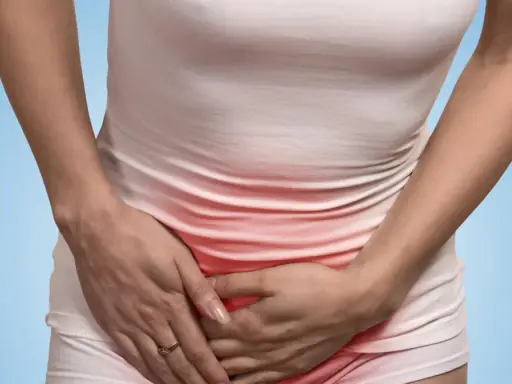 Kobieta trzyma się za brzuch, odczuwając ból w pachwinie. Czerwone zaczerwienienie sugeruje stan zapalny.