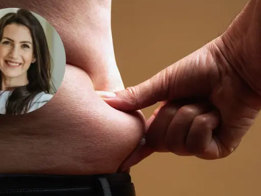 Uśmiechnięta kobieta patrzy na fałd skóry, symbolizując drogę do osiągnięcia **deficytu kalorycznego** i lepszego samopoczucia.