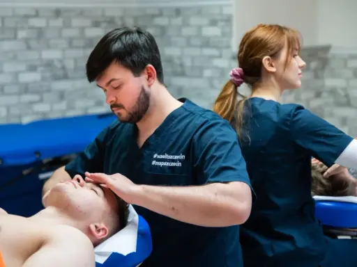 Fizjoterapeuta wykonuje masaż głowy pacjentowi. Studia fizjoterapia ile trwają? To pytanie nurtuje wielu przyszłych specjalistów.