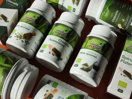 Słoiki i pudełka z produktami **spirulina i chlorella** od Bio Organic Foods. Zielone suplementy diety w proszku i tabletkach.