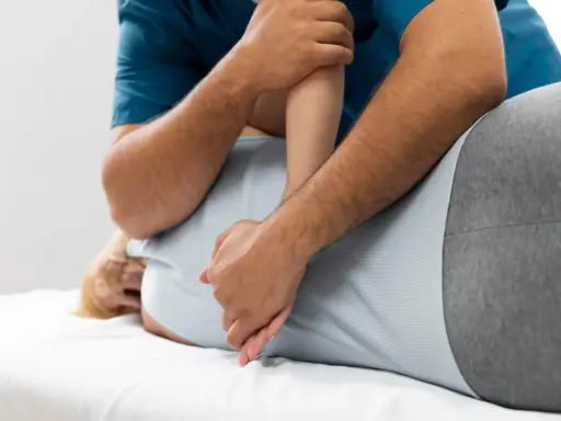 Fizjoterapeuta wykonuje masaż pleców. Czy fizjoterapia może zaszkodzić? Zawsze wybieraj doświadczonych specjalistów.