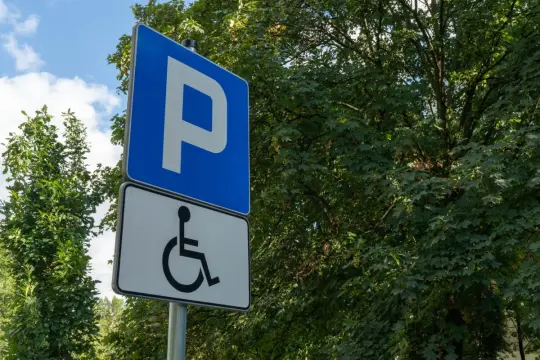 Znak informuje o miejscu parkingowym dla osób z niepełnosprawnościami. To stopień umiarkowany, co się należy.