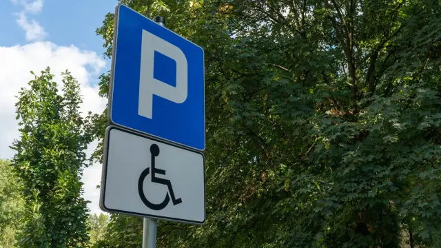 Znak informuje o miejscu parkingowym dla osób z niepełnosprawnościami. To stopień umiarkowany, co się należy.