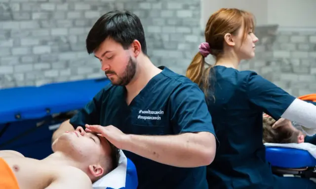 Fizjoterapeuta wykonuje masaż głowy pacjentowi. Studia fizjoterapia ile trwają? To pytanie nurtuje wielu przyszłych specjalistów.