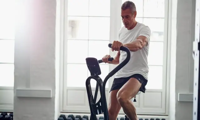 Mężczyzna ćwiczy na rowerze stacjonarnym, który może być dobrym wyborem, jeśli zastanawiasz się, jaki rower stacjonarny do rehabilitacji wybrać.