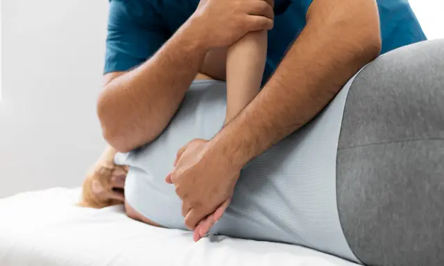 Fizjoterapeuta wykonuje masaż pleców. Czy fizjoterapia może zaszkodzić? Zawsze wybieraj doświadczonych specjalistów.