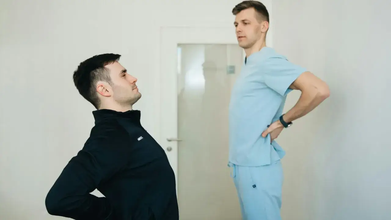 Pacjent z bólem pleców konsultuje się z fizjoterapeutą. Zastanawiasz się, ile kosztuje wizyta u fizjoterapeuty?