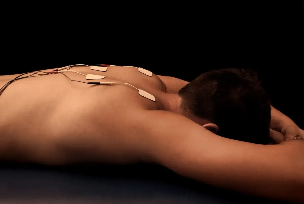 Rehabilitacja TENS: elektrody na plecach pacjenta przygotowane do zabiegu.