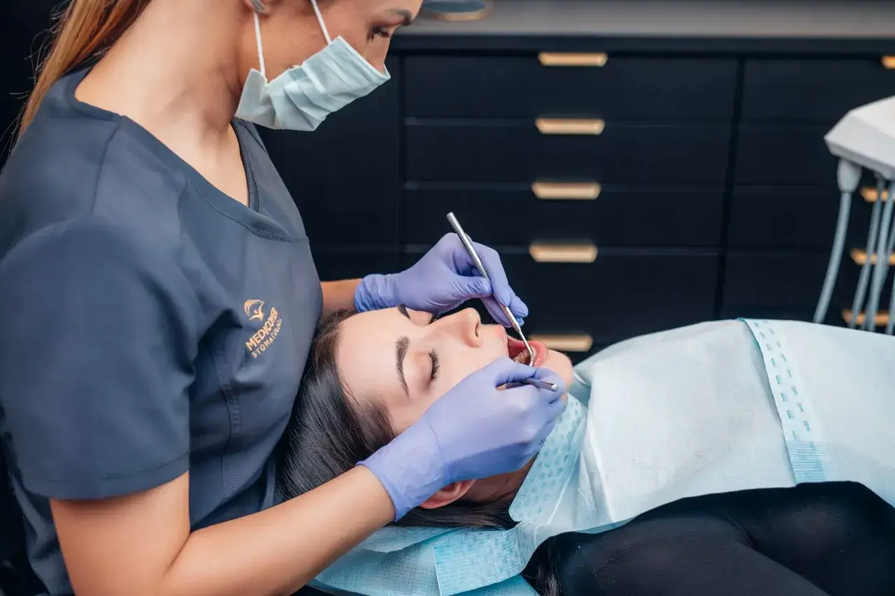 Dentysta w Koninie pomaga pacjentce, która przyszła z bólem zęba.