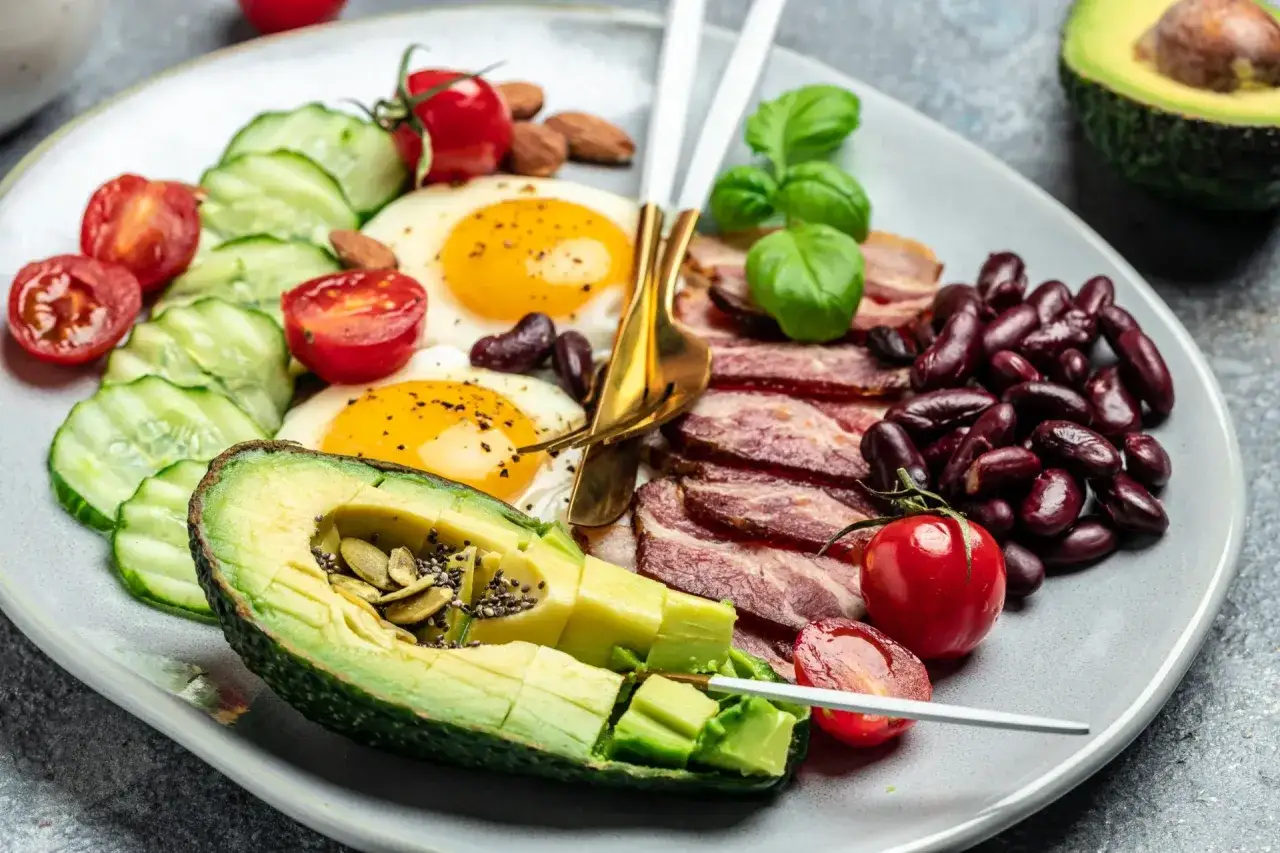 Śniadanie keto: jajka sadzone, bekon, awokado, fasola, pomidorki, ogórek. Tak wygląda dieta keto.