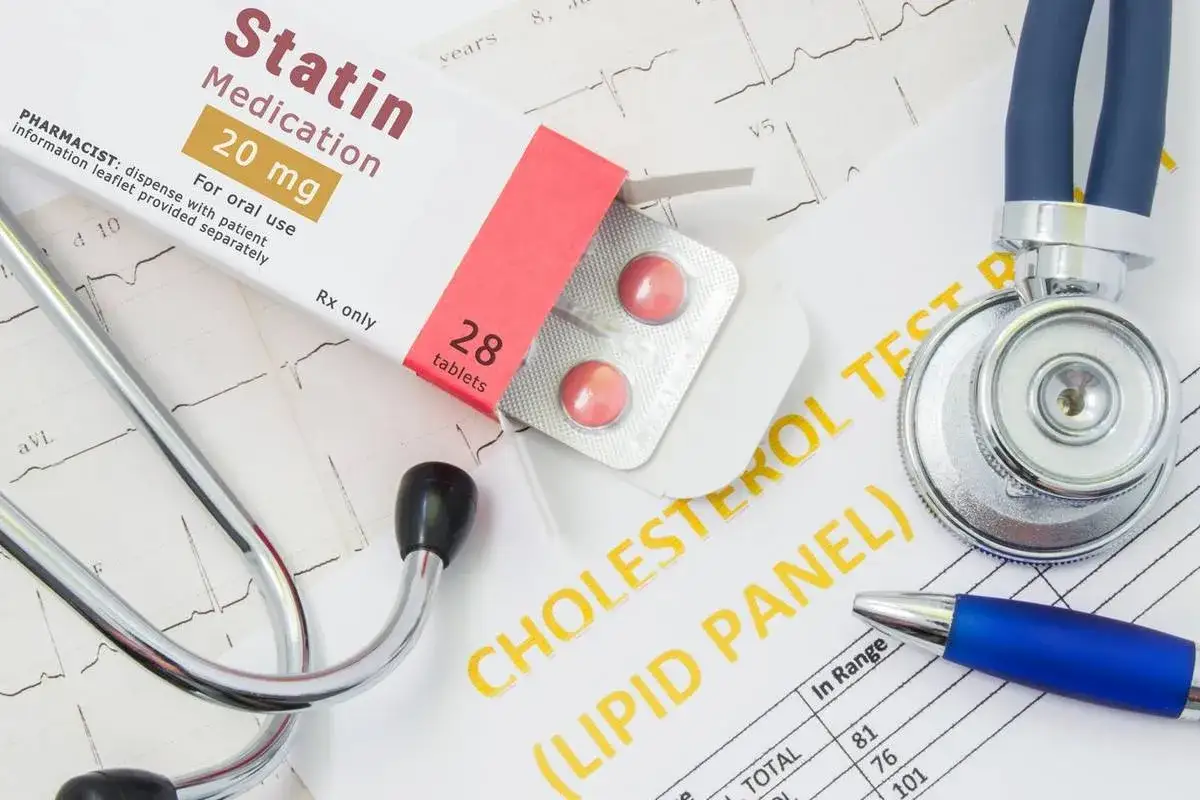 Tabletki na cholesterol na receptę, stetoskop i wyniki badań lipidowych.