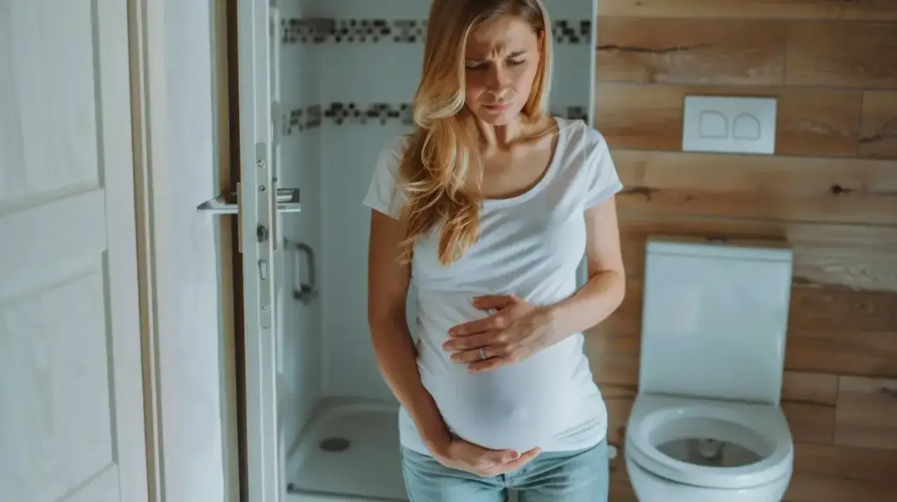 Ciężarna kobieta z bólem brzucha szuka odpowiedzi na pytanie: co na ból brzucha w ciąży?