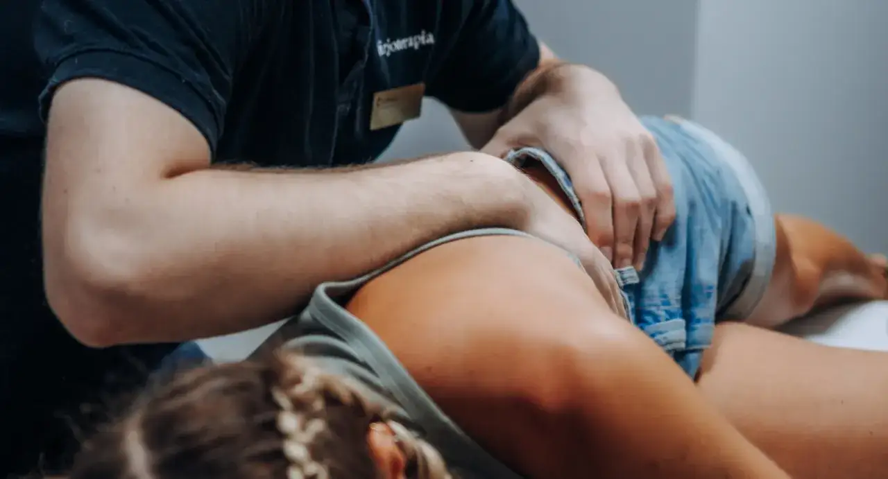 Fizjoterapeuta wykonuje masaż pleców. Czas trwania fizjoterapii zależy od schorzenia i indywidualnych potrzeb pacjenta.